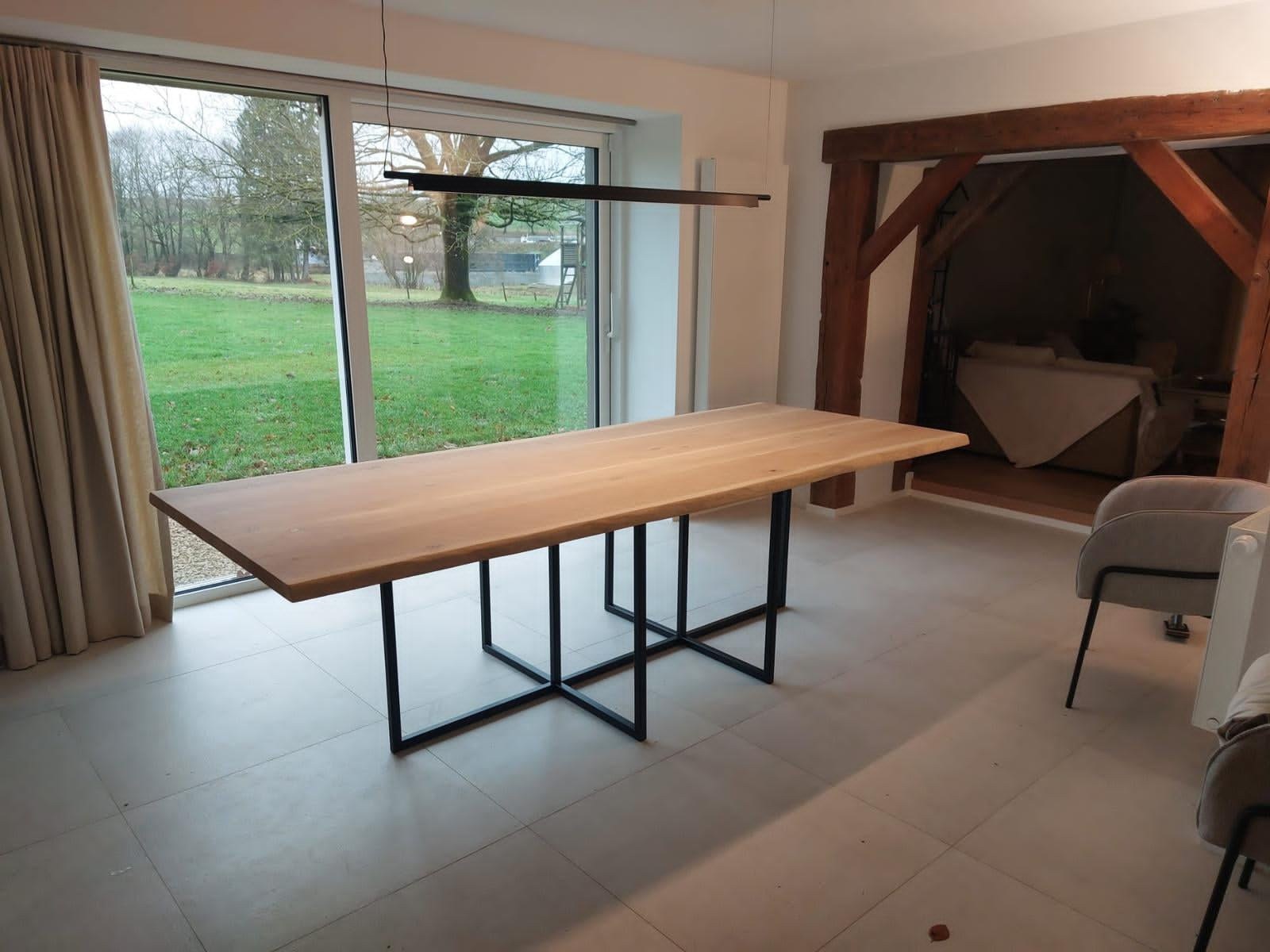 Grande table de salle à manger sur mesure, plateau chêne et piètement acier noir, devant une baie vitrée